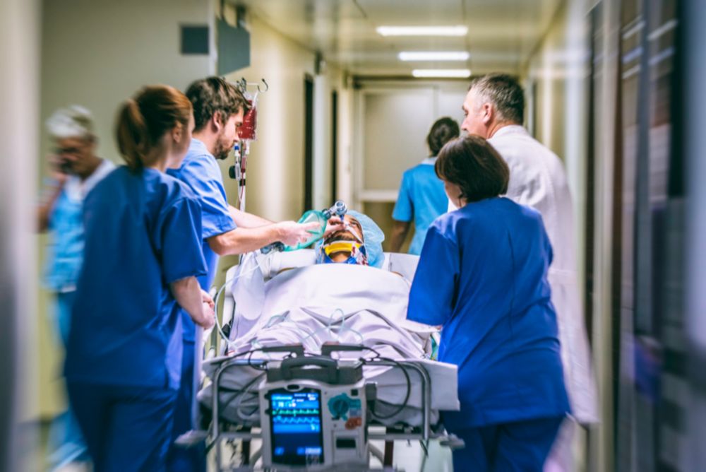 Healthcare team rushing a patient on a stretcher through a hospital corridor, emphasizing urgency and teamwork in critical care.